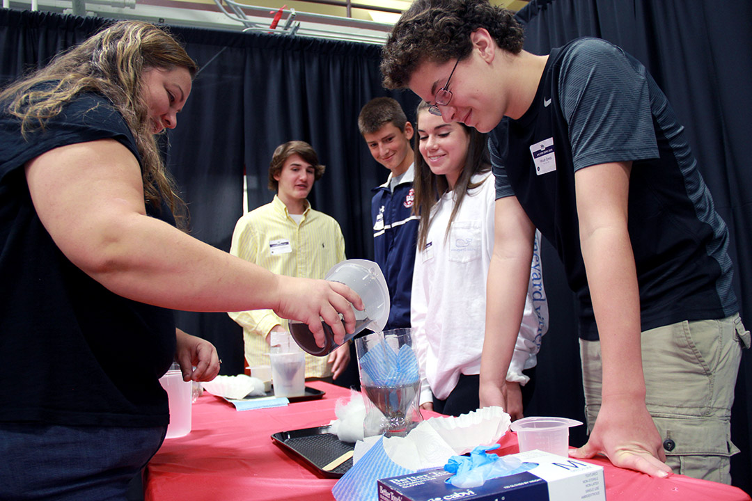 ECBC Chemical Engineer Cindy Learn performs a water filtration experiment with students from Bel Air High School at the APG STEM Expo. Learn also volunteers with ECBC’s STEM program in local schools.