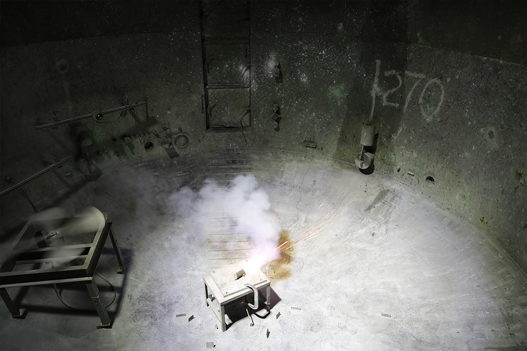 A smoke grenade containing metal organic frameworks designed to block infrared light being tested in an ECBC test chamber.