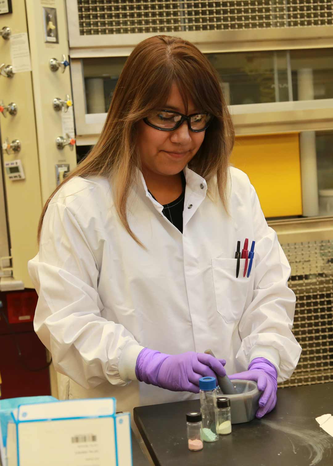 Jennifer Soliz, Ph.D., pulverizes self-indicating colorimetric response materials with a mortar and pestle.