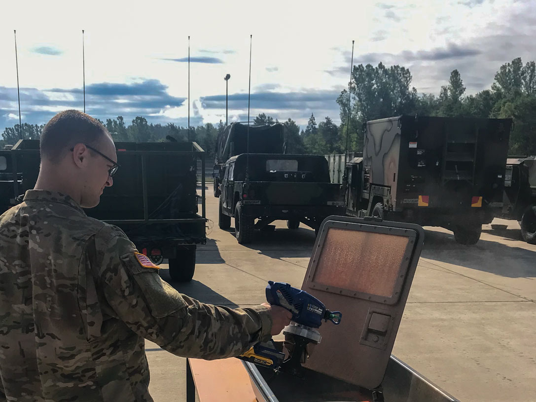 Army Sgt. Richard Dial of the US Army European Command Chemical Biological Radiological Nuclear Explosive Detachment in Grafenwoehr, Germany applies sprayable decontaminant slurry to a scaled-down Humvee door.