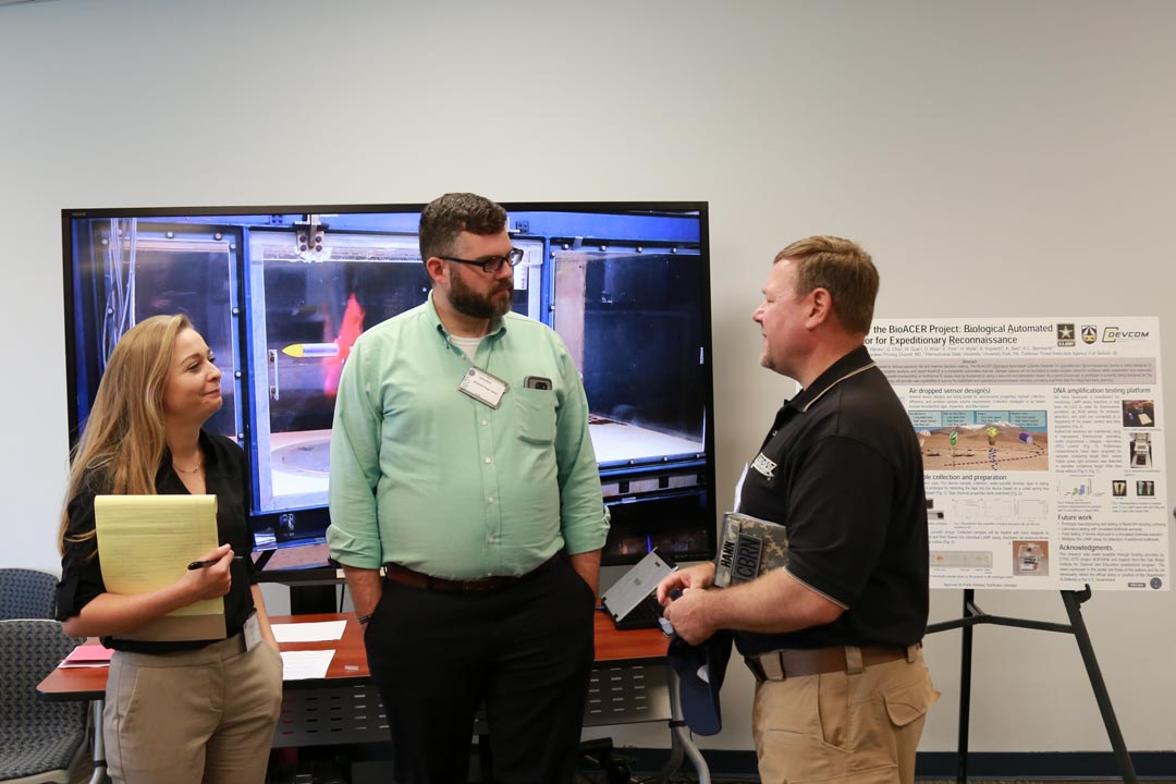 Katherine Broadway, Ph.D., and Phillip Mach, Ph.D. speak with Ronald Hann, Ph.D., DTRA director for chemical/biological technologies, about BioAcer’s remote detection capabilities. (Photo by Shawn Nesaw, CCDC Chemical Biological Center)