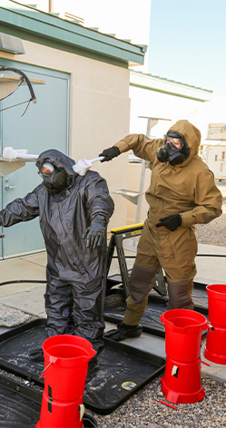 Sgt. Brittany Mattison performs decontamination procedures on Sgt. 1st Class William Anderson. Both Soldiers are assigned to the 690th CBRN Company, Alabama National Guard.