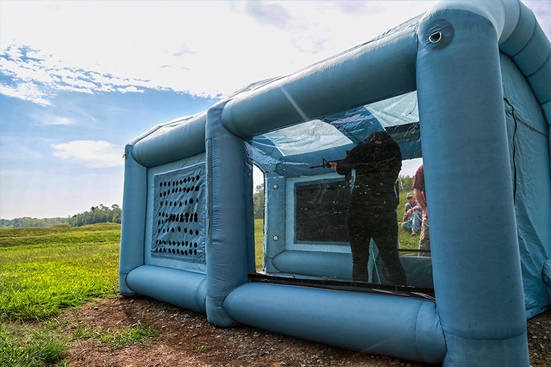 Civilian researchers fire rounds down range from within the inflatable chamber to test the chamber’s ability to properly contain aerosol simulant during a live-fire exercise.