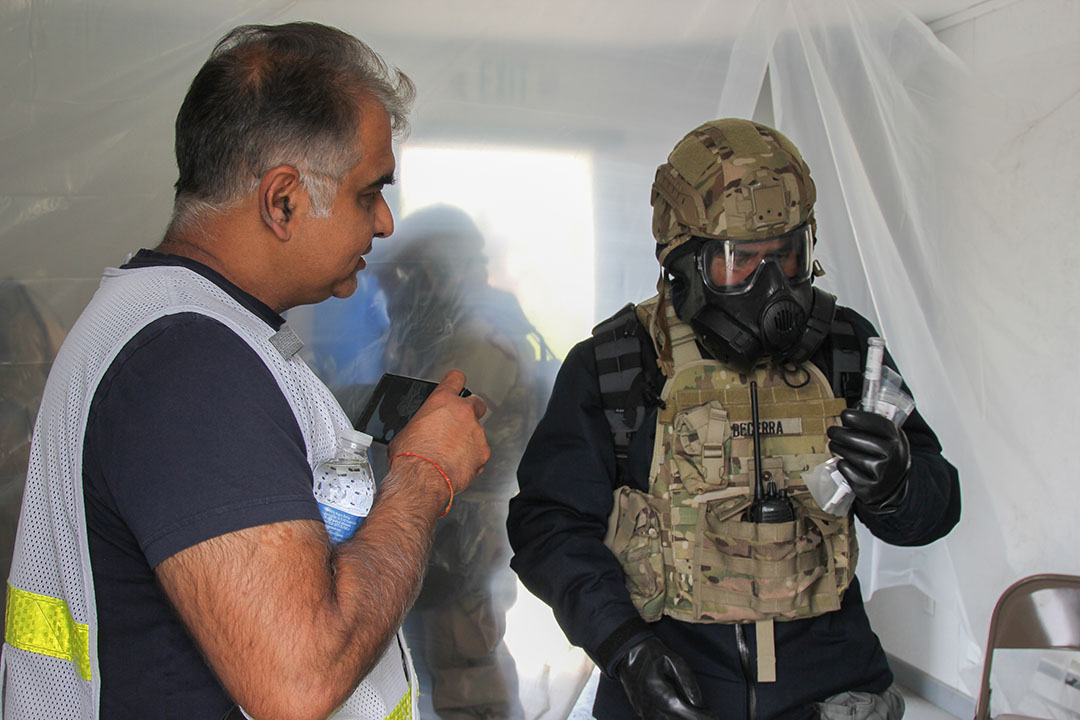 Ashish Tripathi, a DEVCOM CBC research scientist, observes a warfighter using fentanyl detection equipment during CBOA 23 to see how the technology is used in a real-world application. (U.S. Army photo by Ellie White)