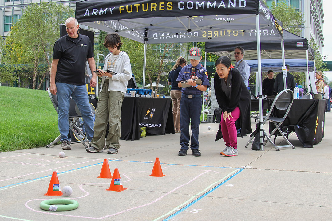 DEVCOM CBC employees, lead engineering technician Gregory Walton and industrial engineer Stella Lee, volunteer at APG STEM Day to teach young scouts and the local community about coding and programming in the STEM field by helping participants guide the Sphero BOLT Coding Robots through various obstacle courses at Aberdeen Proving Ground on September 30, 2023. (U.S. Army photo by Aeriel Storey)