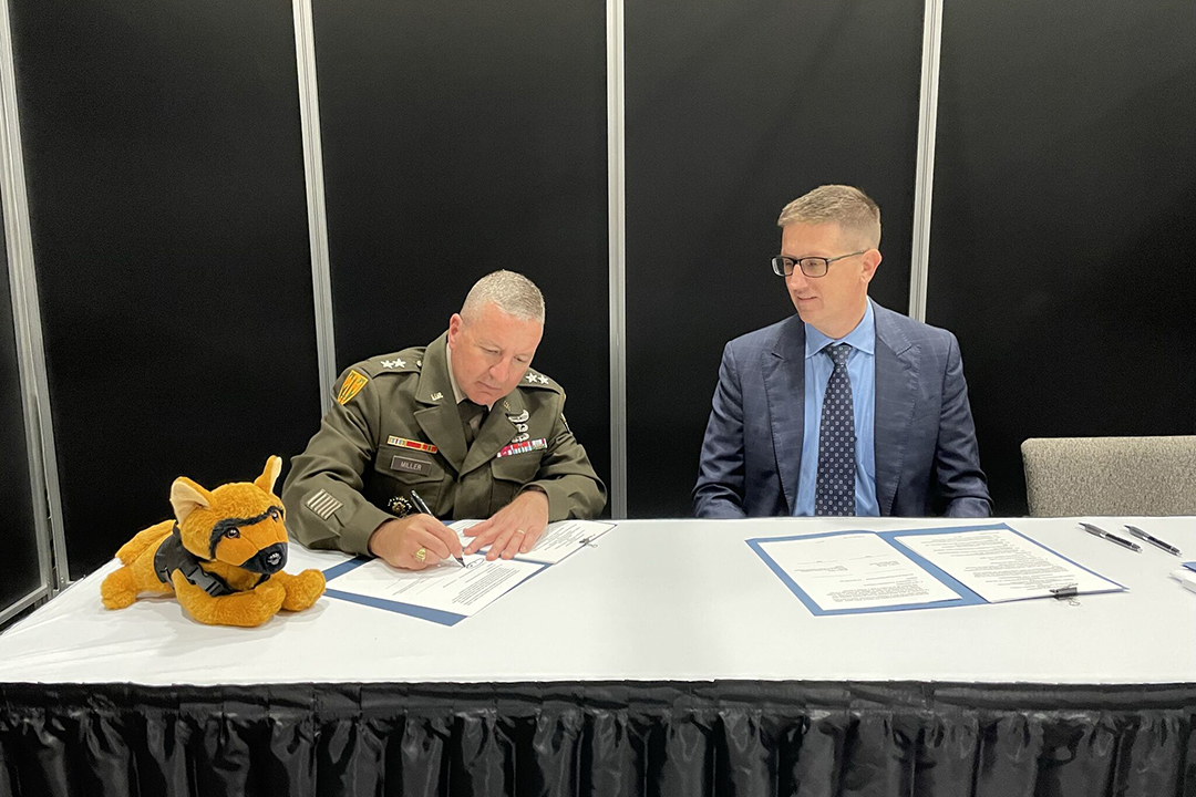 A U.S. Army Provost Marshal General and Army Corrections Command, Commanding General, Major General Duane R. Miller and DEVCOM CBC Director Mr. Michael Bailey sign an MOA to enable CBC scientists to provide training for U.S. Army MWD during the 2023 AUSA Annual Meeting & Exposition on October 9. (U.S. Army photo by Heather Roelker)